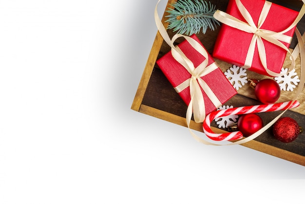 디자인을위한 크리스마스 요소입니다. 리본, 크리스마스 장난감, 전나무 가지, 크리스마스 사탕, 눈송이, 흰색 배경에 격리와 빨간 선물 상자와 나무 상자. 평면도. 평평하다