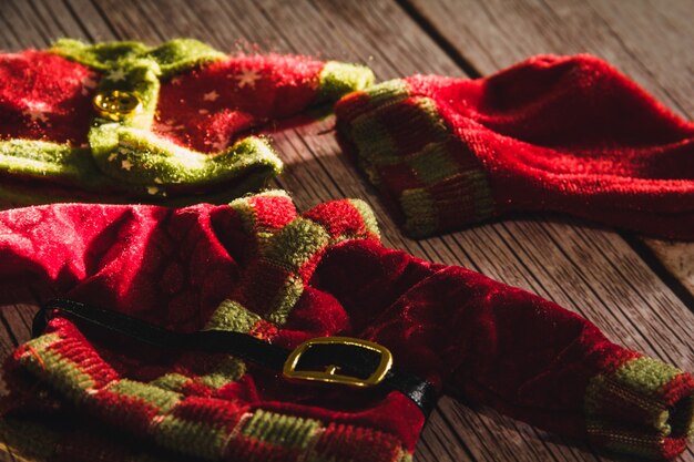 Christmas elf clothes on wooden background. Selective focus.