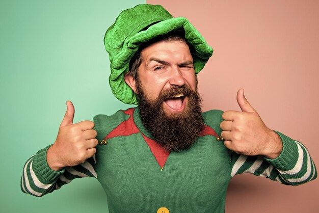 Christmas elf Elf concept Happy celebration Bearded elf Winter carnival Best day ever St Patricks day Hipster with beard wearing green party costume thumbs up Cheerful man celebrate holiday