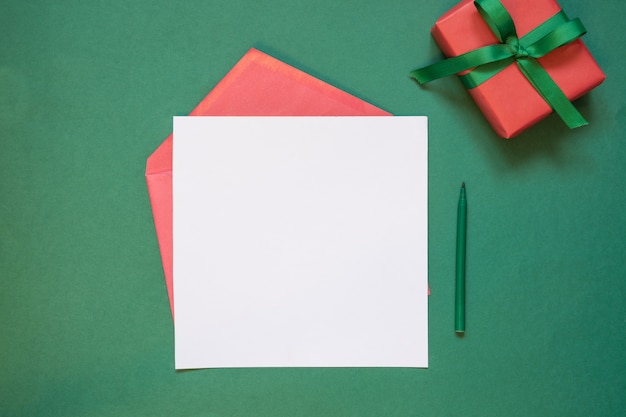 Christmas empty blank letter to Santa or invitation with giftbox on green. 