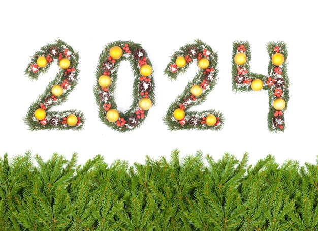 写真 クリスマス・イブの背景と2024の数字 クリスマス・ツリーの枝が白い背景に隔離された