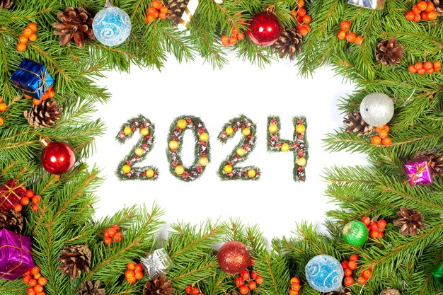 写真 クリスマス・イブの背景と2024の数字 クリスマス・ツリーの枝が白い背景に隔離された