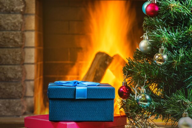 Christmas eve New year tree and Gift boxes near cozy fireplace in country house