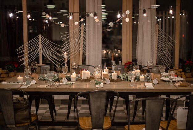 크리스마스 저녁. 양초 유칼립투스 화환과 흰색 접시를 제공하는 세련된 테이블 디자인