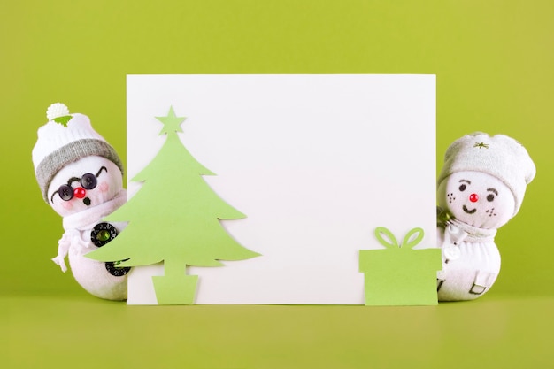Рождественские снеговики из ткани на зеленом