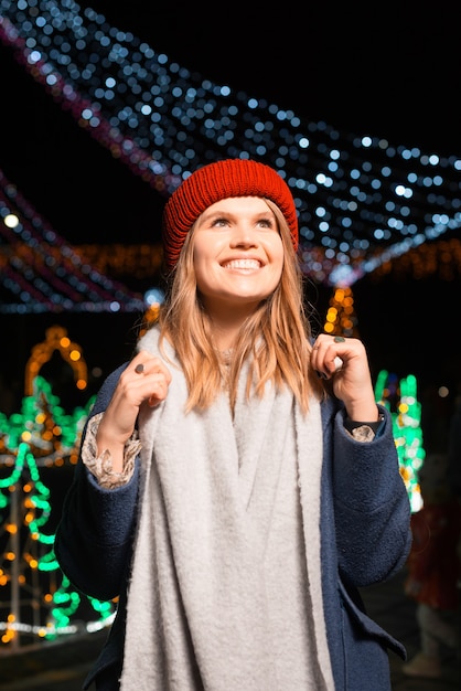 Christmas fair is now open. Young girl is very excited outdoors, at night.