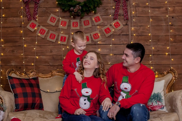 Рождество Семейное счастье Портрет папы, мамы и сыновей на диване у себя дома