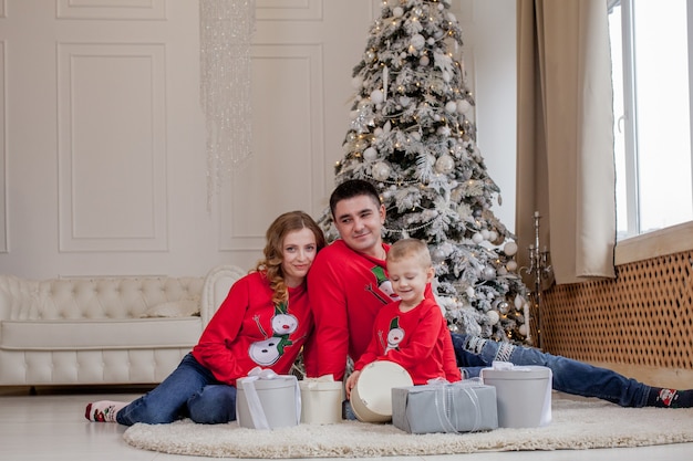 Christmas Family Happiness Portrait of dad son sitting on a floor at home near the Christmas tree