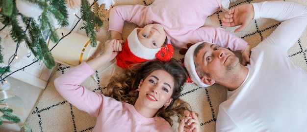 Natale famiglia e felicità vista dall'alto di papà mamma e figlia che indossano