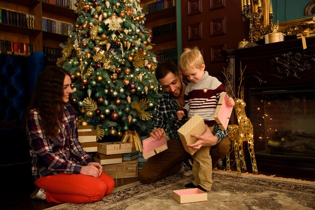 밤 크리스마스 트리 인테리어에 마법의 빛을 찾고 크리스마스 가족 오픈 현재 선물 가방