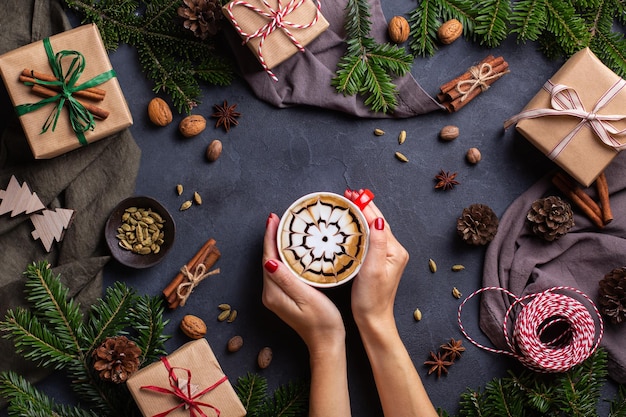 Christmas female hands with gift boxes and cup of coffee