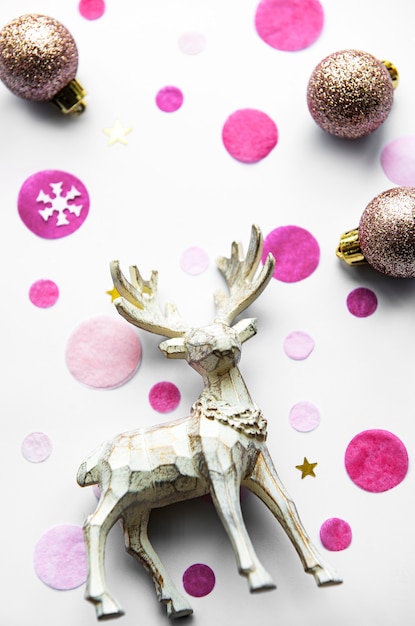 Christmas festive background with beautiful deer, golden balls and confetti on white background