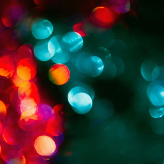 Christmas festive bokeh blur background. Rain on the window. Colorful abstract city lights concept