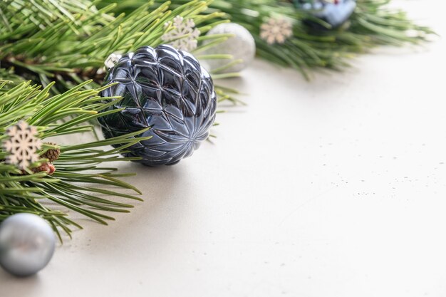 白いボールと常緑の枝を持つクリスマスのお祝いの構成。上面図