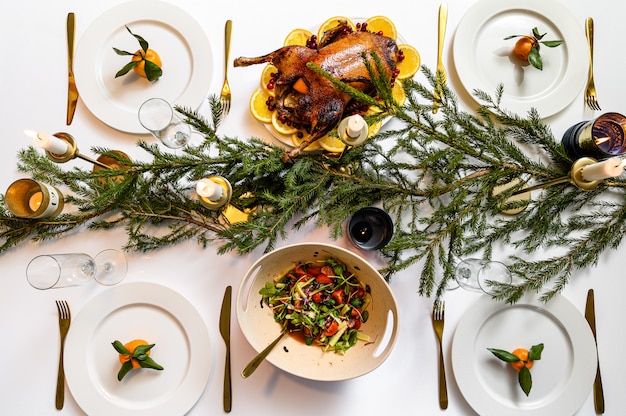 Foto cena festiva natalizia. pasto tradizionale delizioso di festa e mani delle persone che li mangiano. tavolo decorato con gustosi piatti. flat ley. tavolo bianco