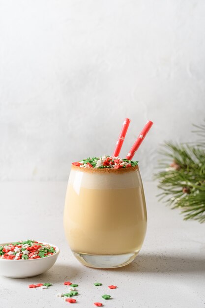 Christmas festive eggnog with sprinkles colorful holiday stars on white.