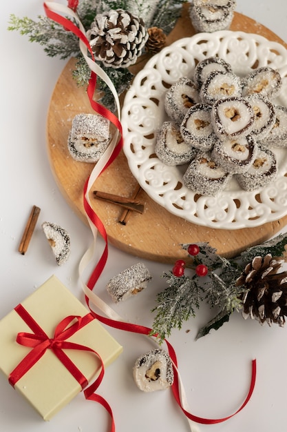 写真 クリスマスのお祝いのギフトボックスと白い背景の季節の装飾とお菓子