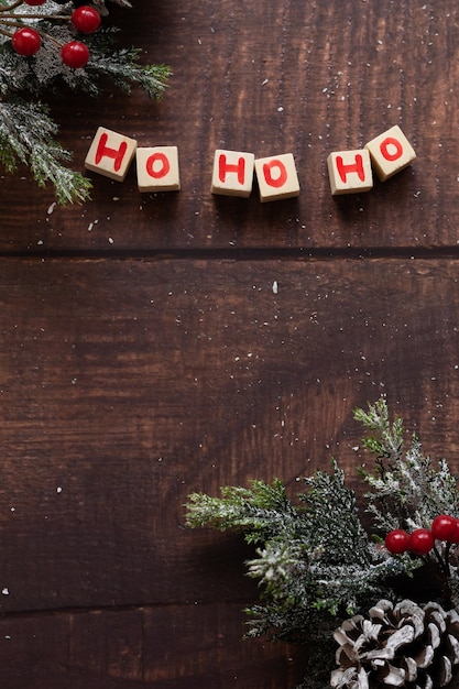 Рождественский праздничный текст Хо Хо Хо и сезонные украшения на деревянном фоне, место для текста
