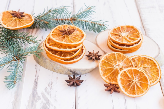 Sfondo festivo di natale con rami di abete, arance essiccate e stelle di anice su tavola in legno rustico