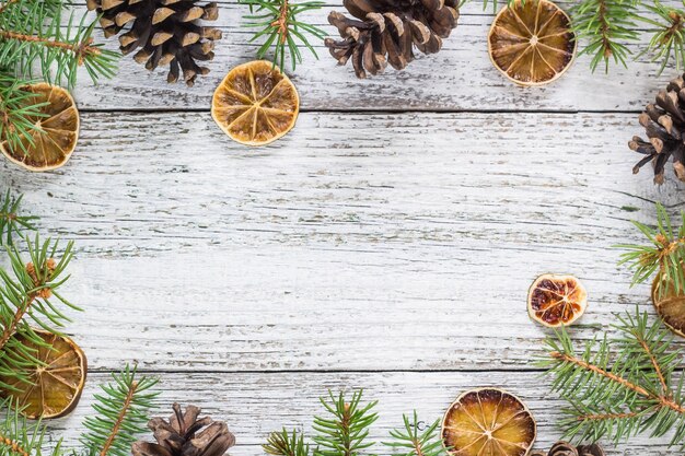 Christmas fir branches with cones and dry lemon slice. Top view with copy space for your text