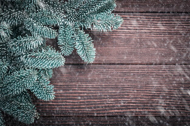 Christmas fir tree branches Christmas balls gift box wooden snowflakes and stars on old brawn wooden background for your xmas greetings Top view with copy space Christmas greeting card