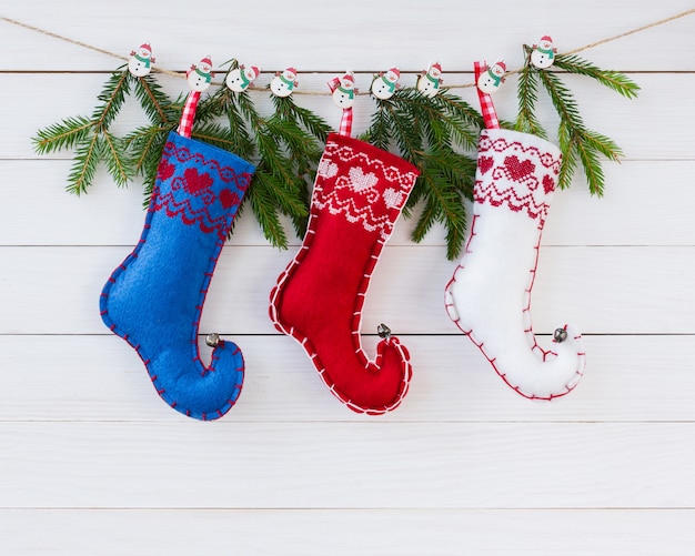 Christmas fir tree and fleece socks on white wooden board  with copyspace. Christmas background