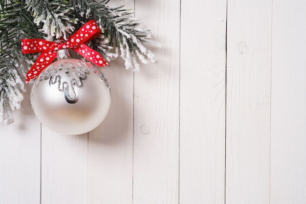 Рождественская елка и украшение с красной лентой на деревянной доске