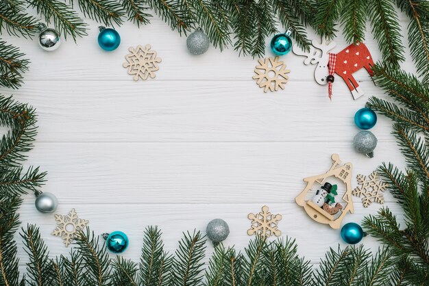 Christmas fir tree with decoration and glitters on wooden background. Christmas background on the white wooden desk