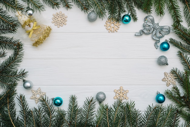 Christmas fir tree with decoration and glitters on wooden background. Christmas background on the white wooden desk