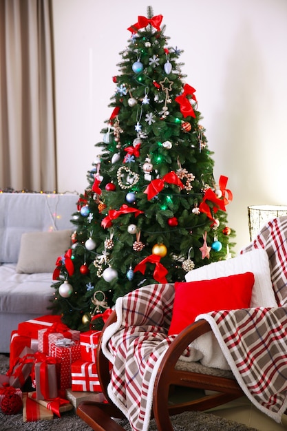 Christmas fir tree with gifts in living room