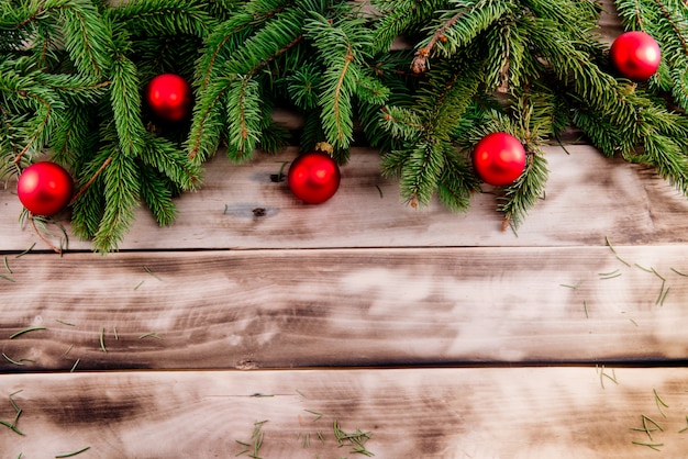 天然木の上の赤いボールとクリスマスのモミの木