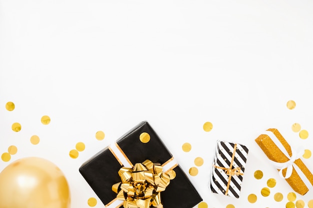 Рождественская квартира лежала. Рождественские подарки, черная и золотая оберточная бумага на белом фоне с золотым конфетти