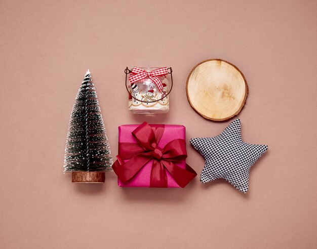 Christmas flat lay with fir tree, gift box, wooden log and toys