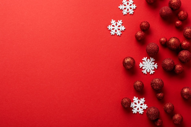 Christmas flat lay with fir tree, with Christmas tree made of red toys balls decorated golden confetti in red envelope on red.  