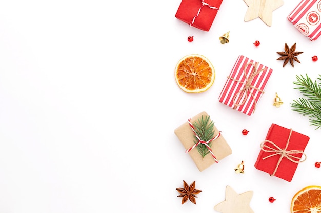 Foto natale piatto giaceva con scatole regalo, decorazioni natalizie e copia spazio su sfondo bianco.