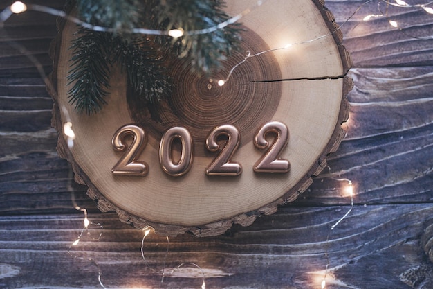 크리스마스 플랫은 나무 탁자에 있는 황금 숫자 2022 및 새해 장식