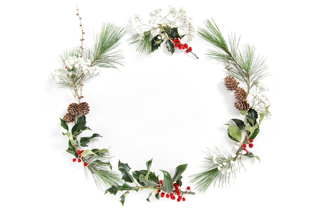 Christmas floral flat lay. Frame with ilex leaves and red berries