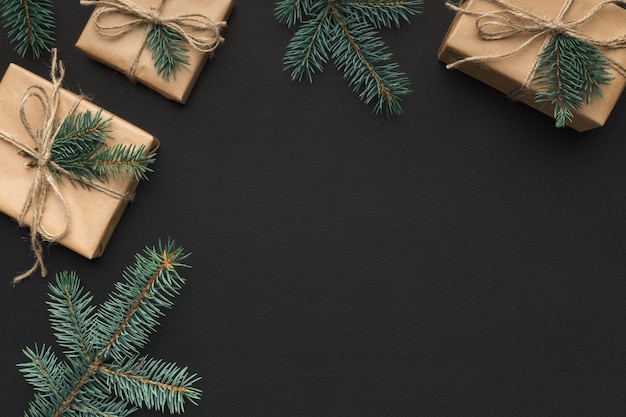 Christmas frame of fir branches and gift boxes on black background