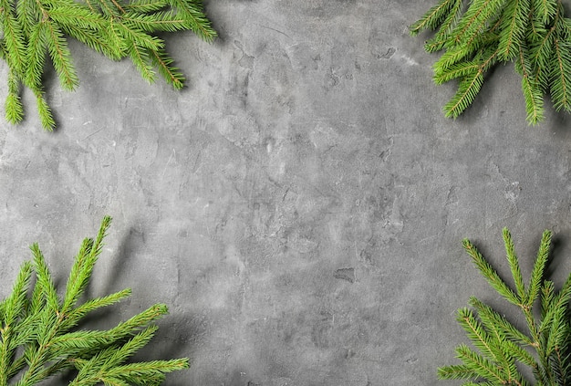 Christmas frame from fir branches on grey background