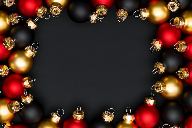 Christmas frame made of red black and gold christmas balls on a black background