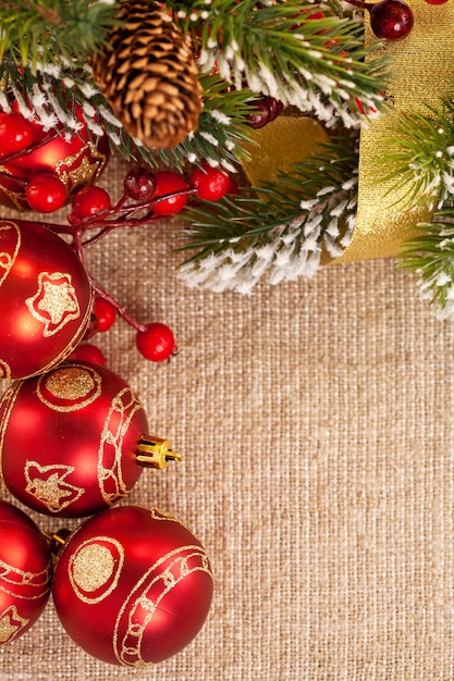 Christmas frame with branch and decorations on burlap background