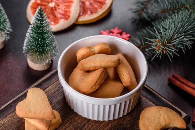 Christmas frame with fir tree branches, gingerbread cookies, spices and dried orange rings