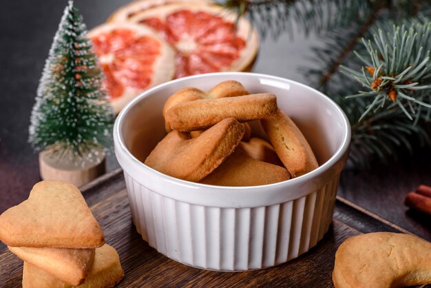 Christmas frame with fir tree branches, gingerbread cookies, spices and dried orange rings