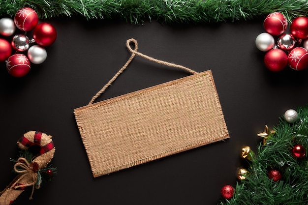 A christmas frame with a ornaments, garland with an empty sign