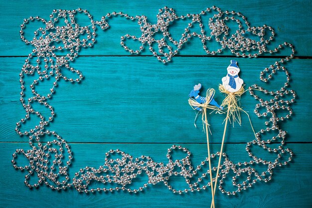 Christmas frame with silver beads on a blue wooden background