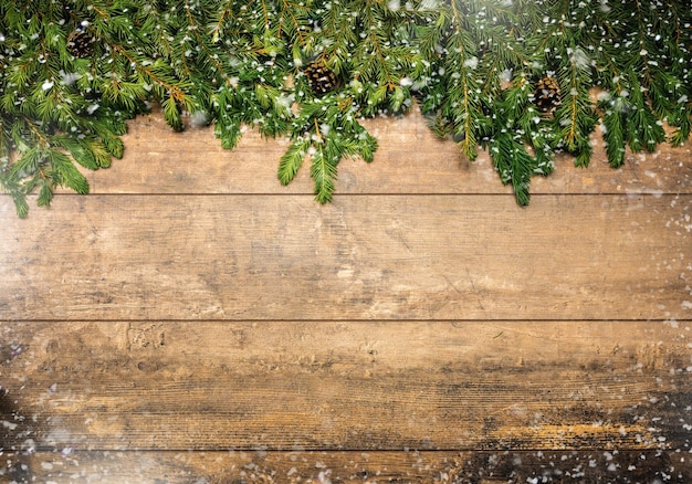 Christmas framework with snow and cones Christmas wooden background with snow fir tree Christmas rustic background with Christmas tree branches cones snow and red berries winter festive