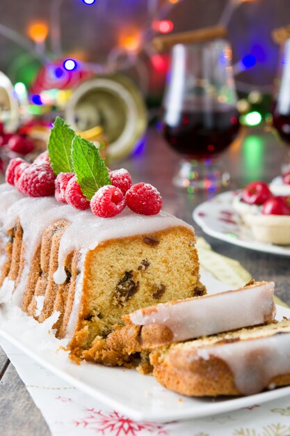 クリスマスフルーツケーキと素朴な木製のテーブルの上のクリスマスの装飾