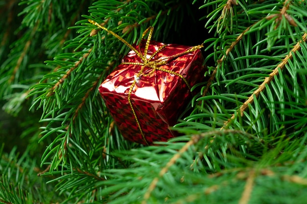 Рождественский подарок на фоне елки крупным планом