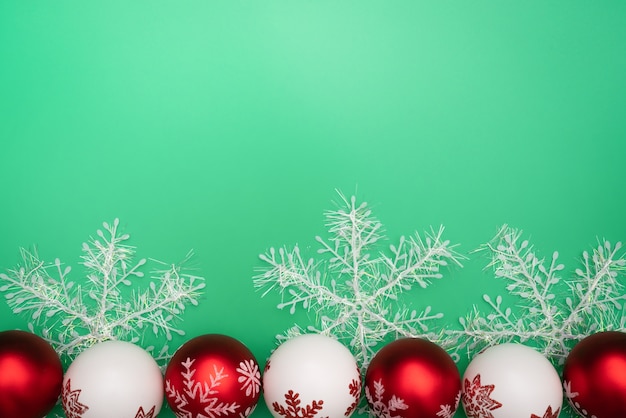 Christmas gift, bell and ball on green background. Flat lay, top view