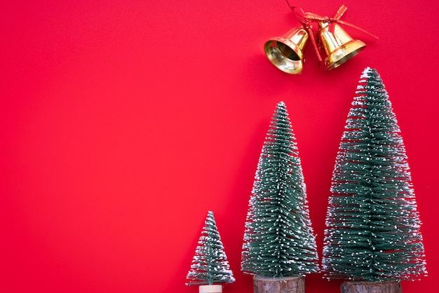 Christmas gift, bell and pine tree on red background. Flat lay, top view